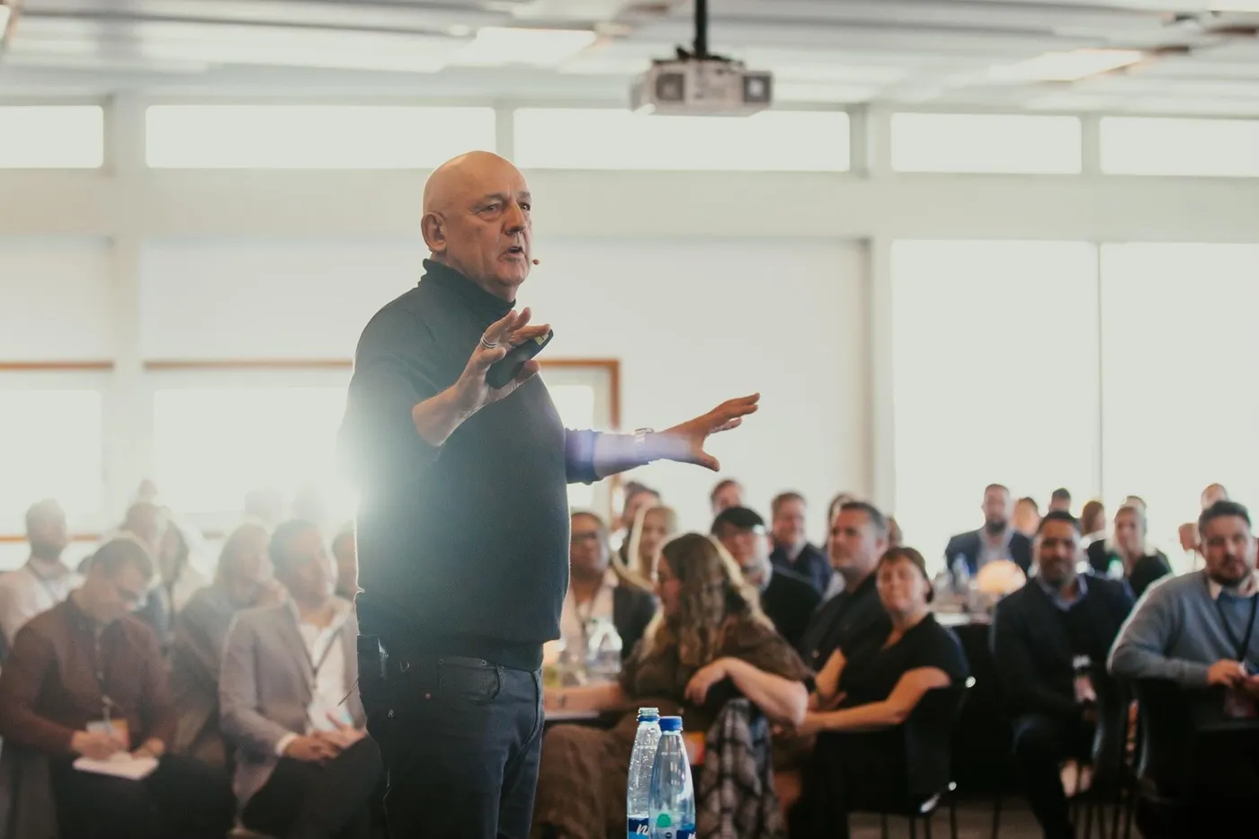 Gilbert Enoka speaking on stage at a corporate event